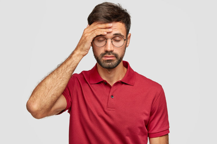 a man holding his head due to headache