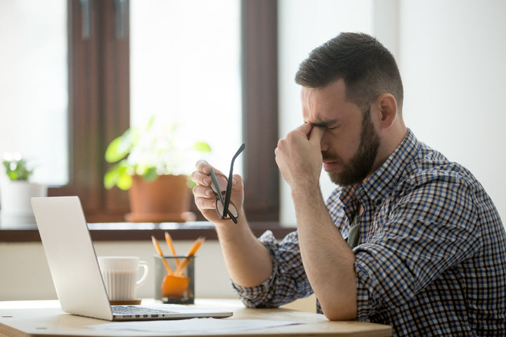 a man sitting on a chair and tired of his headache