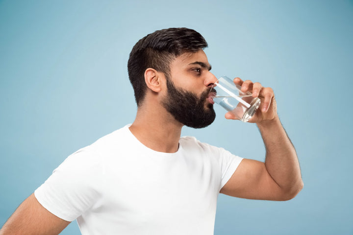 a man drinking water from a glass