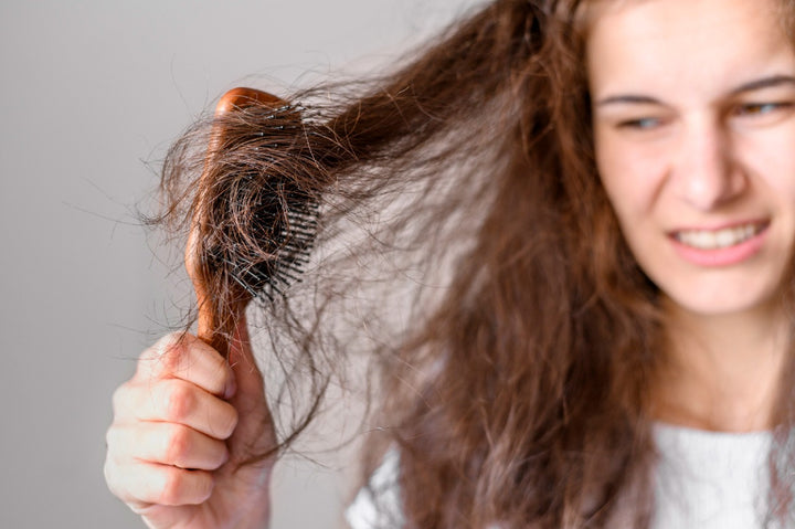 a woman looking at her tangled hair knots