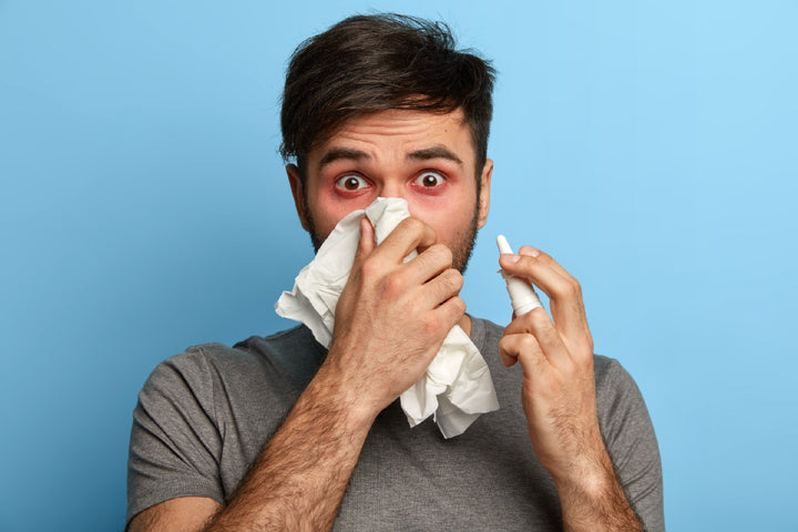 a man using a handkerchief while sneezing