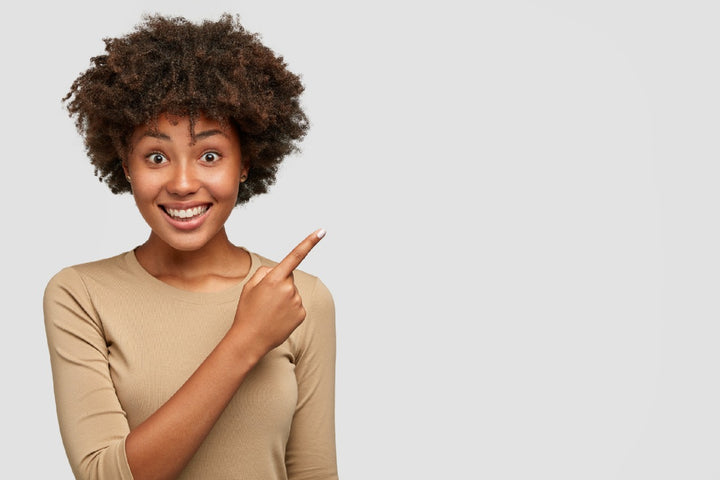 a woman with dark complexion pointing towards her left