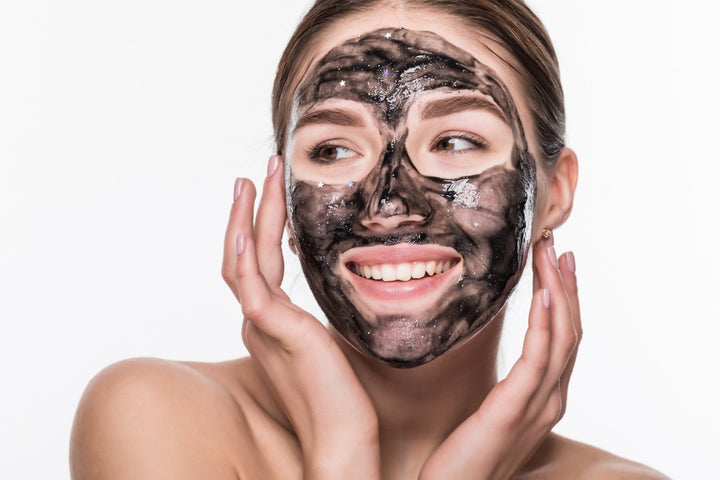 a woman applying charcoal mask